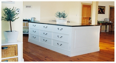 A custom made, white, Hand Painted French Provincial style Kitchen Island with Adelaide black Granite benchtop, made by Compass Kitchens